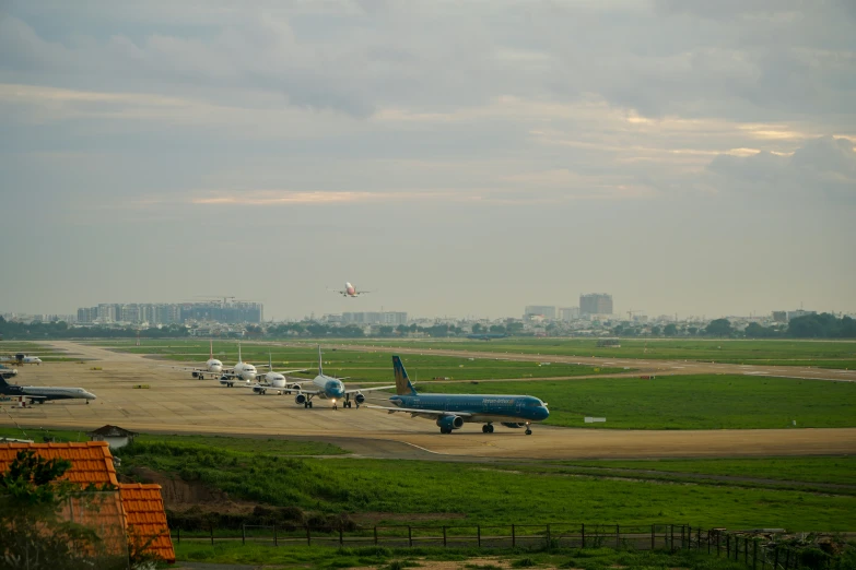 airplanes at airport with green grass and sky in the background