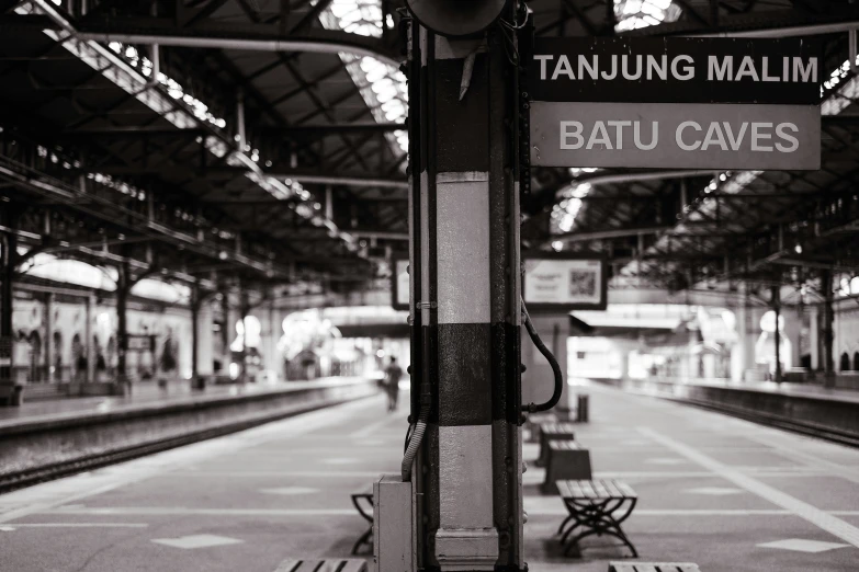 a train station with benches and signs in front of it