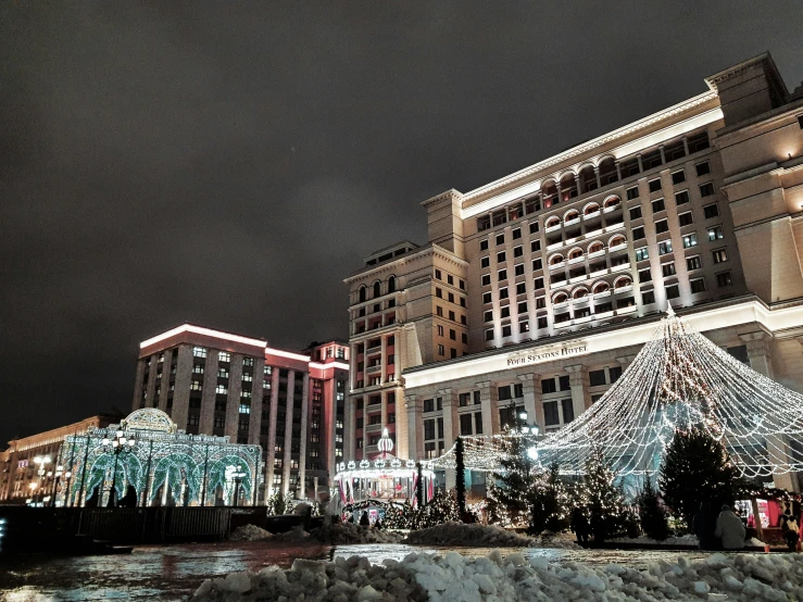 christmas lights hang at night on the outside of buildings