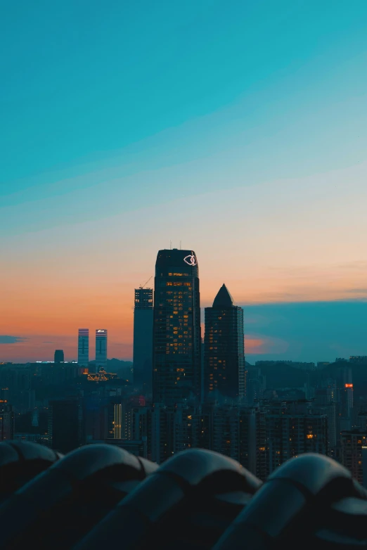 a city with tall buildings in the distance at sunset