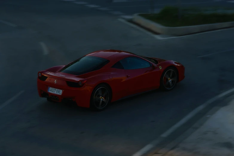 a very sleek red sports car driving down a street