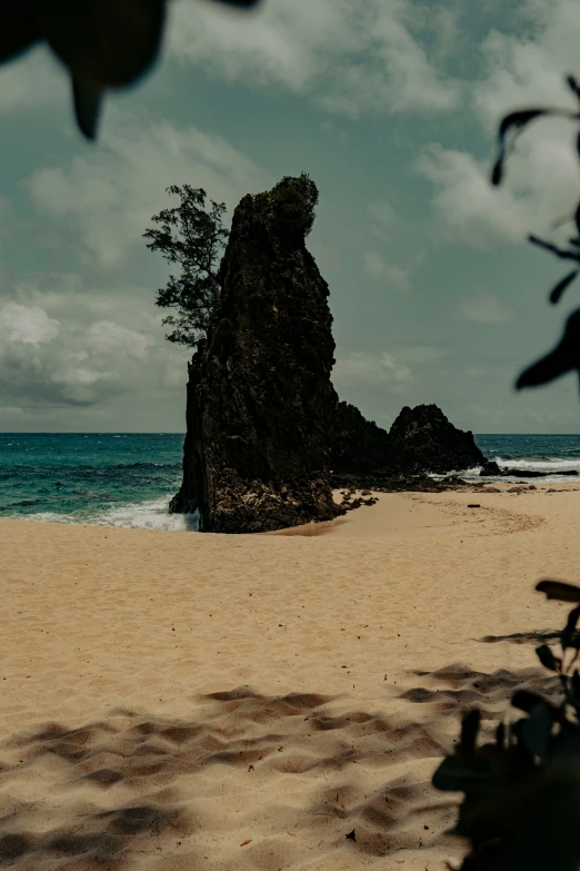 an empty sandy beach and rocky cliff at the ocean