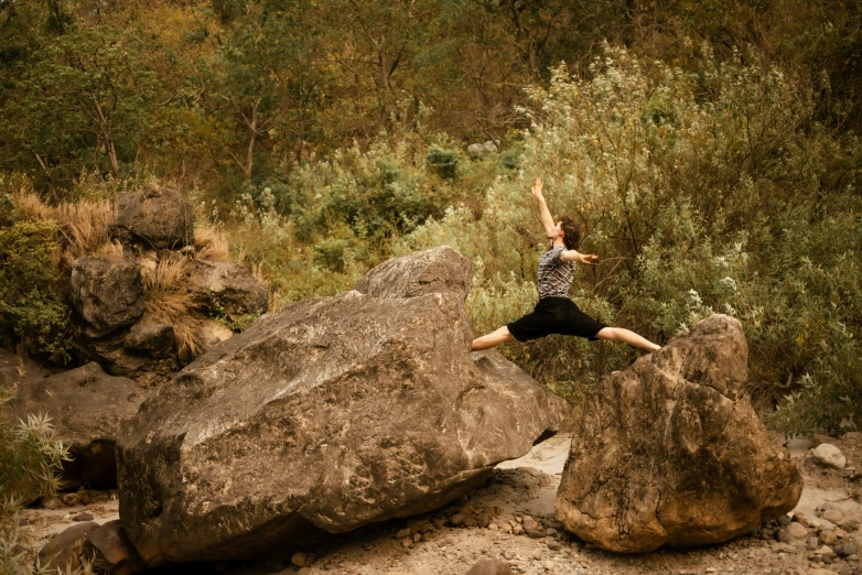 a person jumping in the air from some rocks