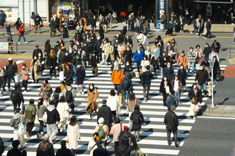 an overhead view of people walking across a crosswalk