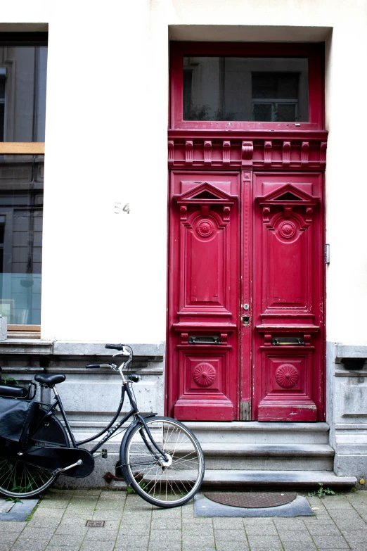 a bike parked in front of a red door