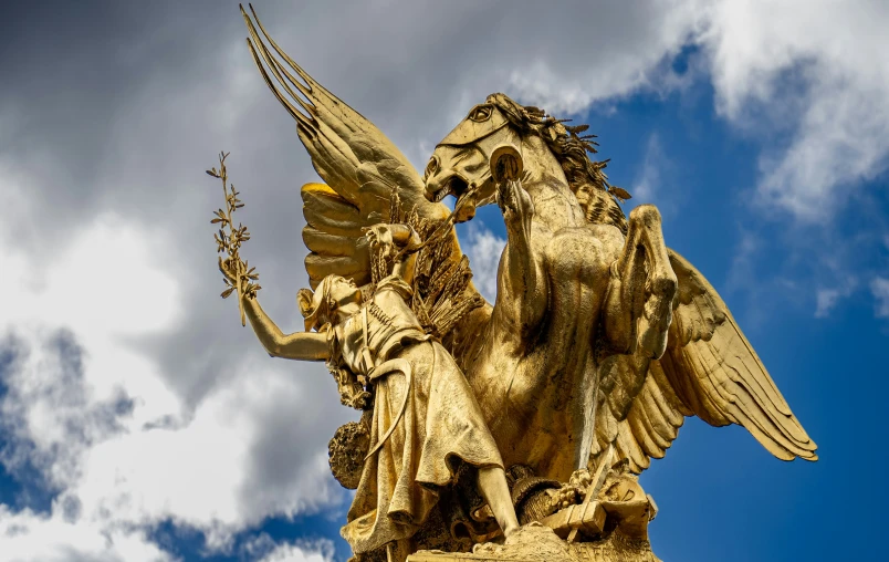 two statues holding a vase are shown against a blue sky