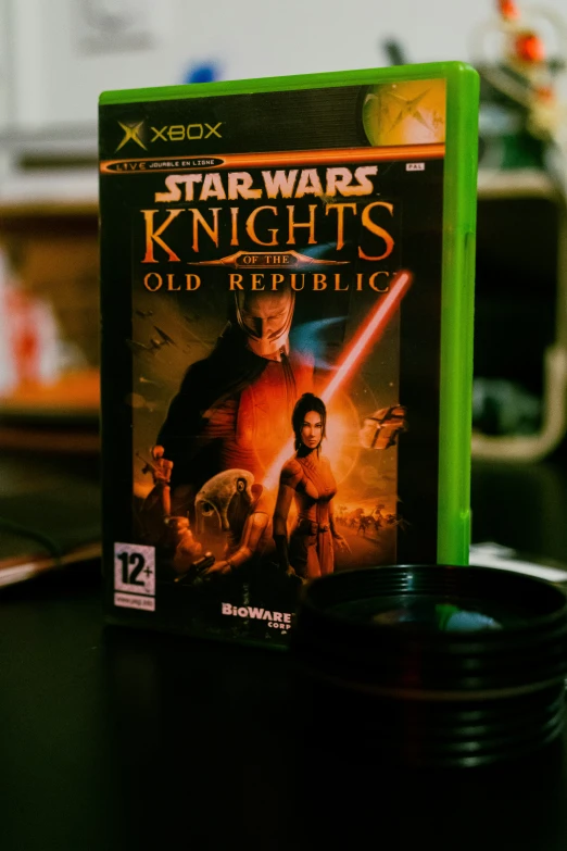 a star wars knight's oil bottle sits next to an dvd on top of a table