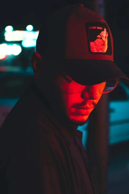 man wearing hat standing in front of building at night