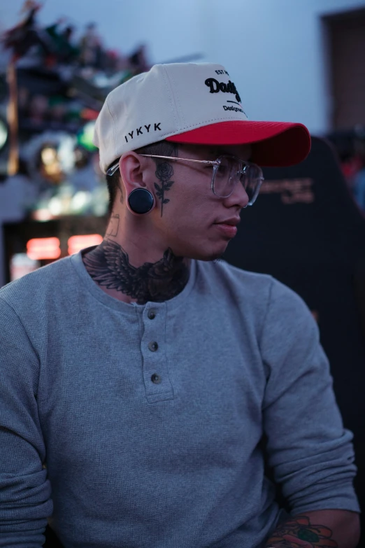 a man with tattoos is wearing a baseball cap and a pair of sunglasses