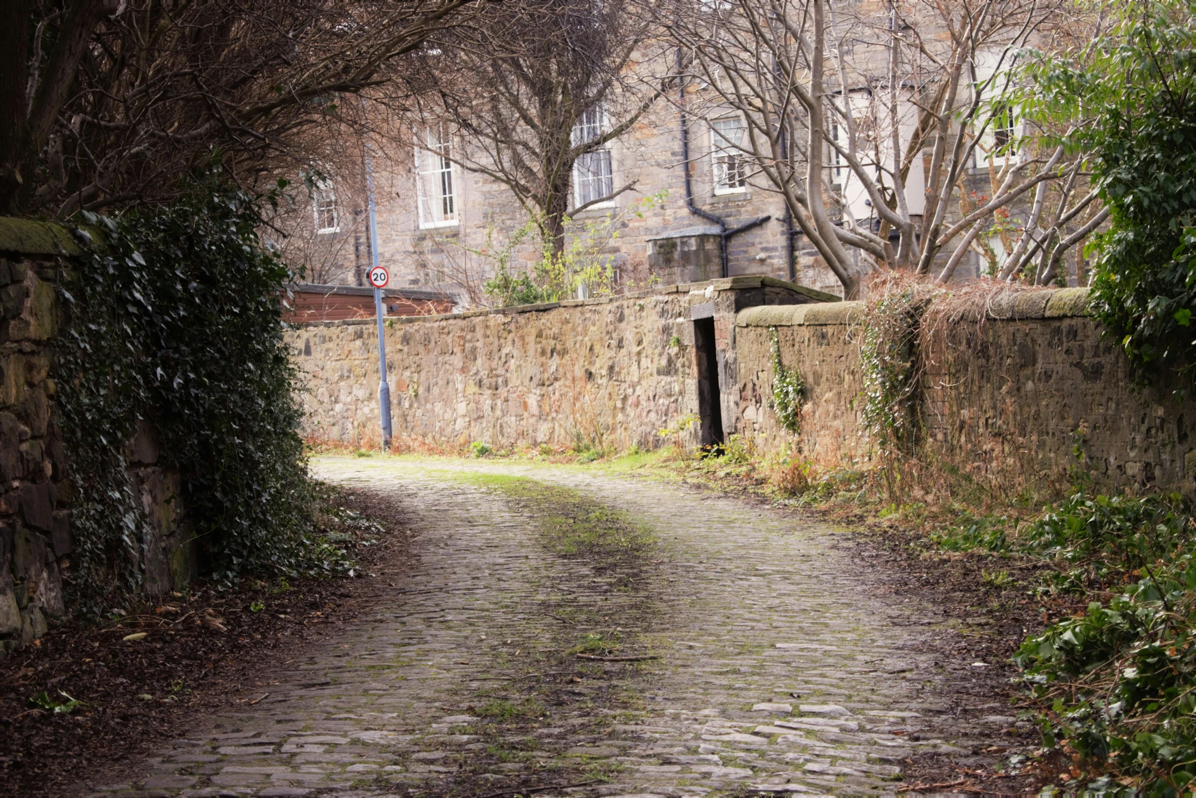 the pathway is next to a large brick building