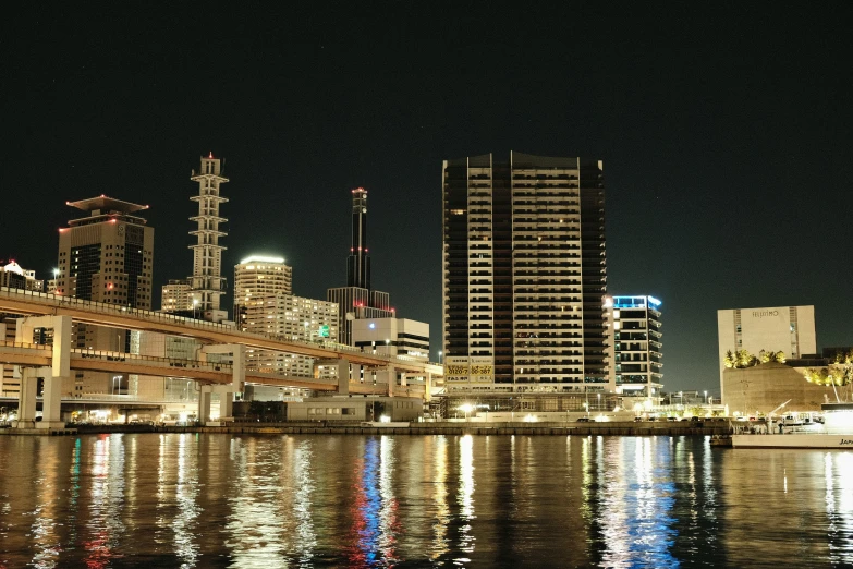 a cityscape of skyscrs reflecting in water at night