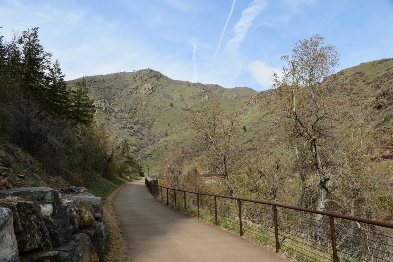 a path winding through the mountains with a view of a hill