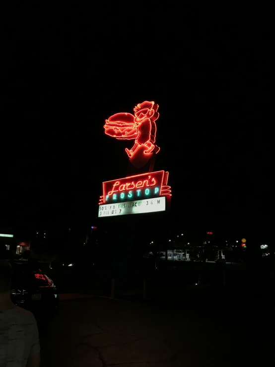 people are walking past a large sign on the side of a building