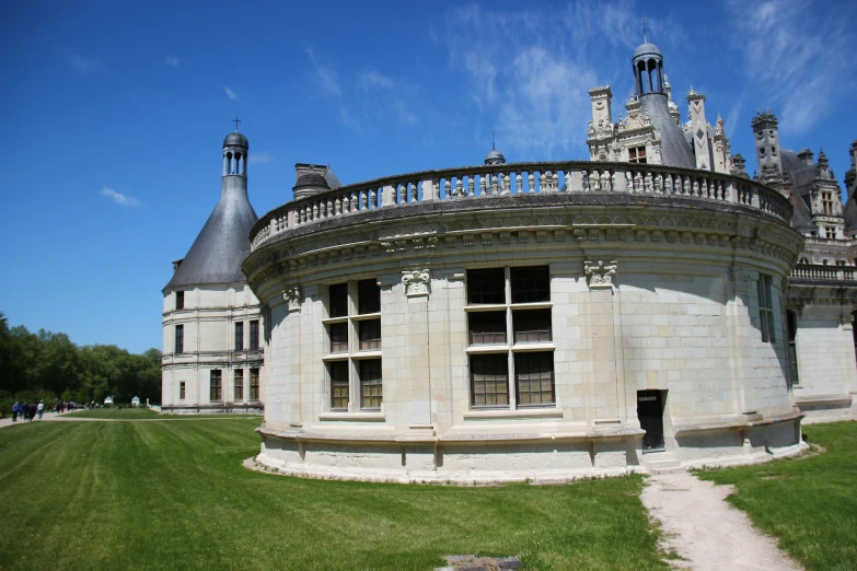 a big round building sits in a grassy field