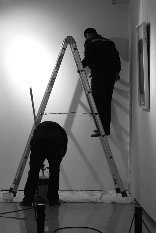 two men with buckets are painting the walls together