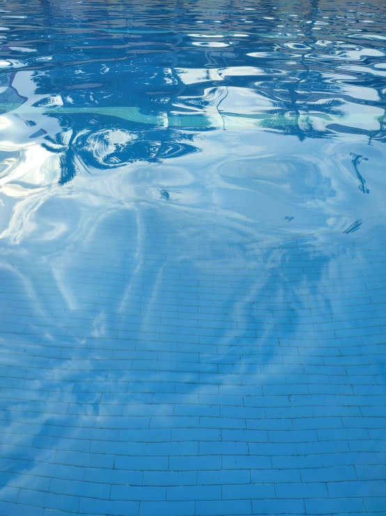 blue pool tile and water reflecting a sail boat