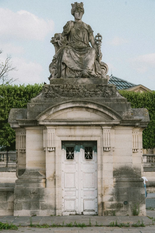 an old fashioned monument with a queen statue on top