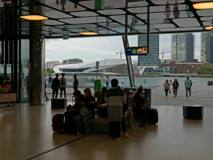 several people standing and sitting in a waiting area