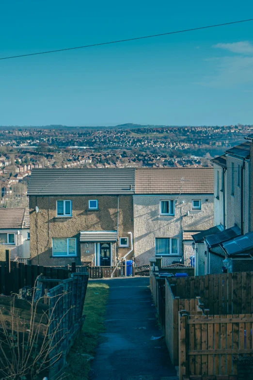 a path next to a fence and two story homes