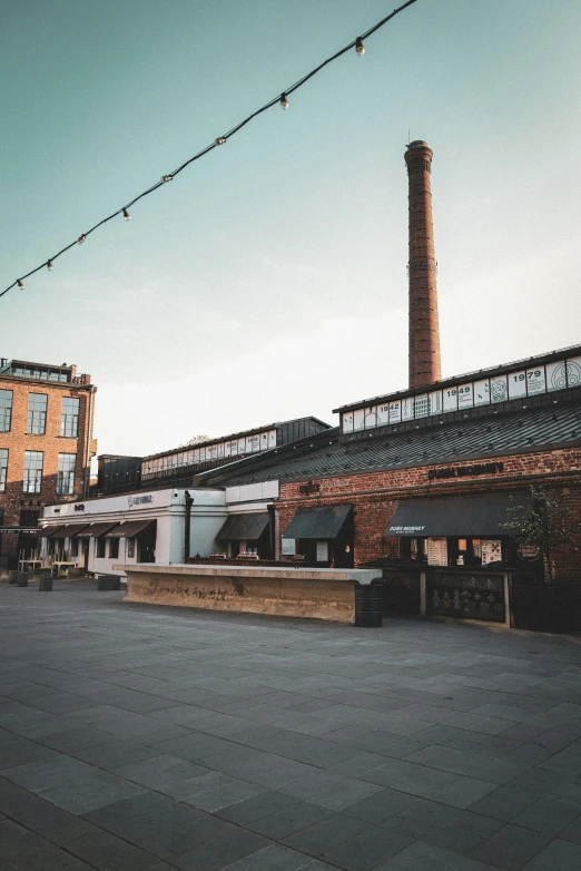 an industrial building with a steel chimney stands in a deserted street