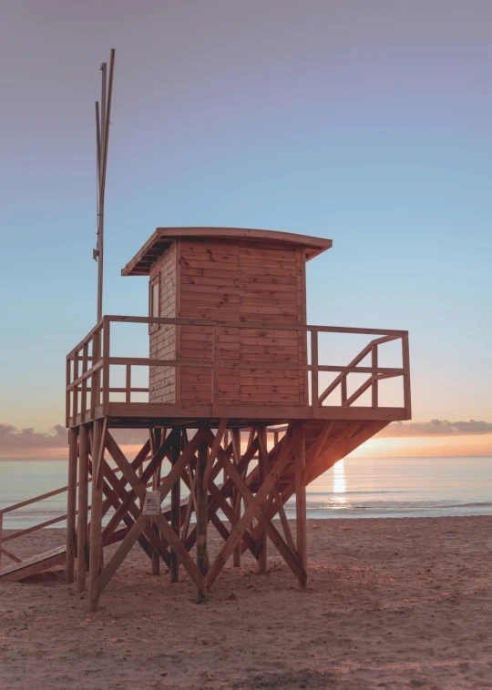 a wooden structure sitting on top of a sandy beach