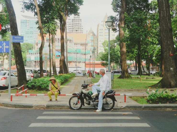 a person sitting on the back of a motorcycle near another biker