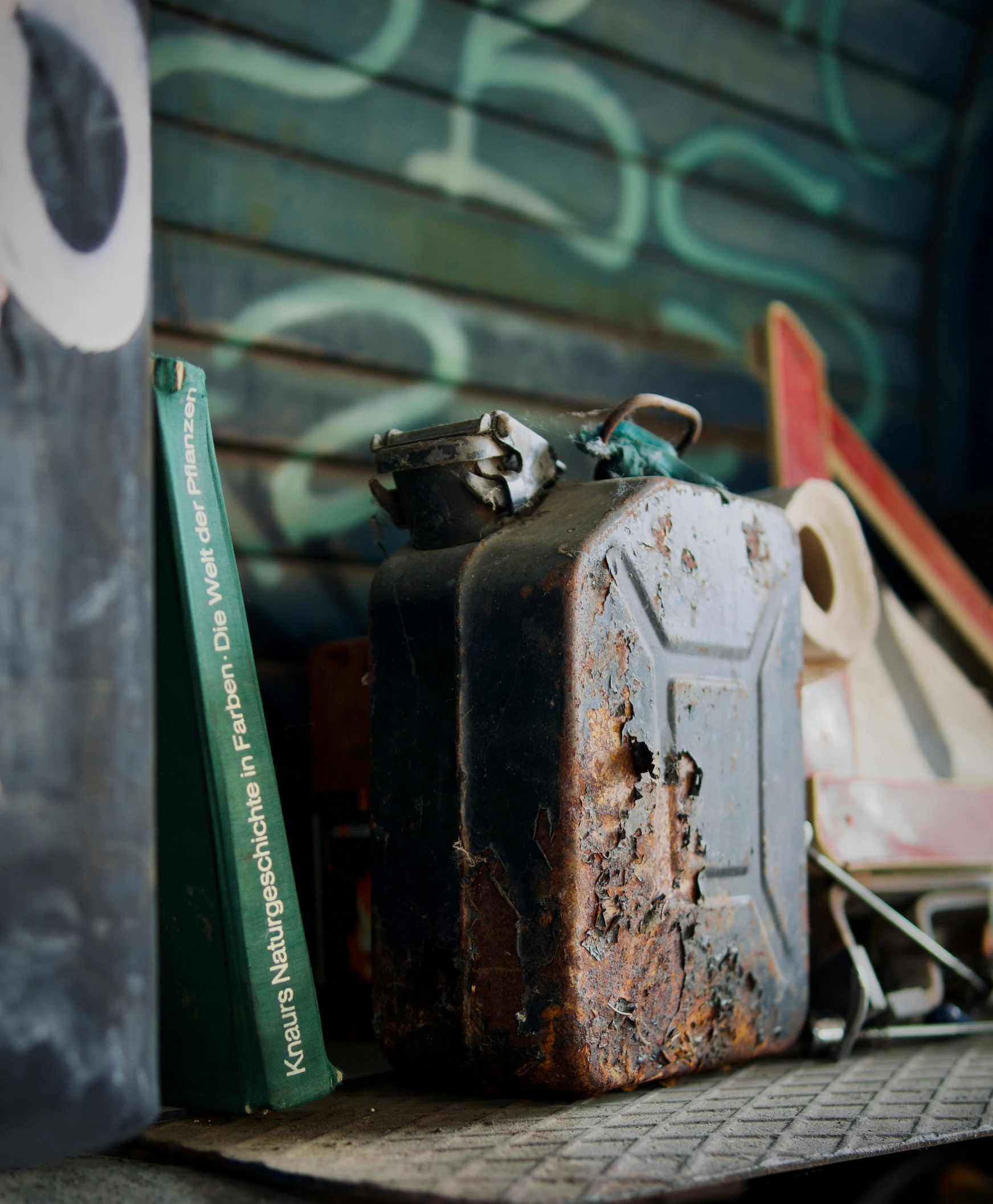 a rusty metal container with a green book on the table