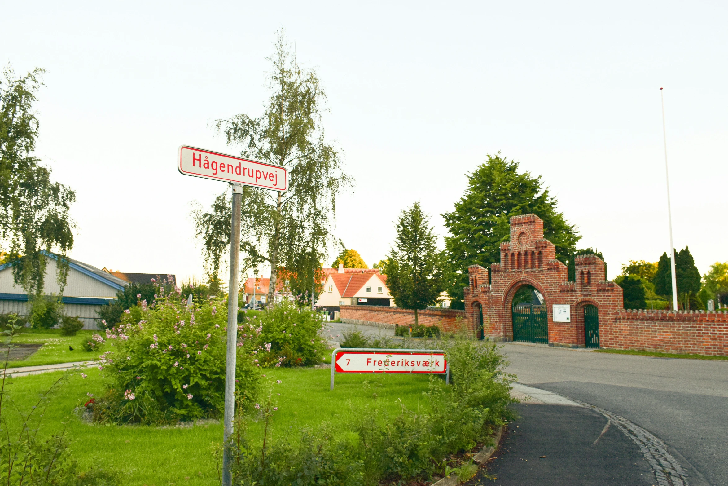 a building behind a road sign in the country