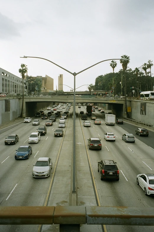 several cars travel down an overpass on a cloudy day