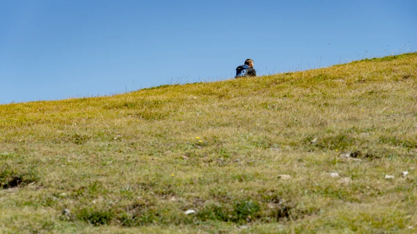 a person standing on a hill overlooking the sky