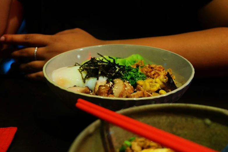 someone's hands taking a picture of their food in a bowl