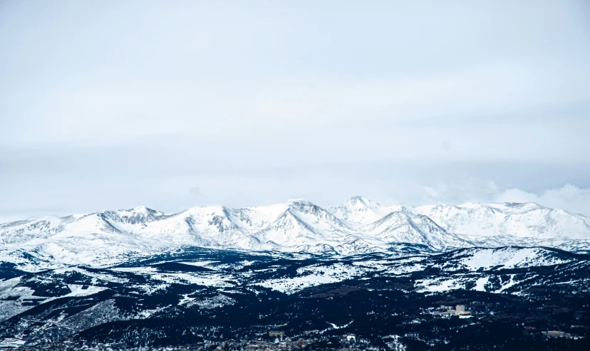 there are some snow mountains with some clouds