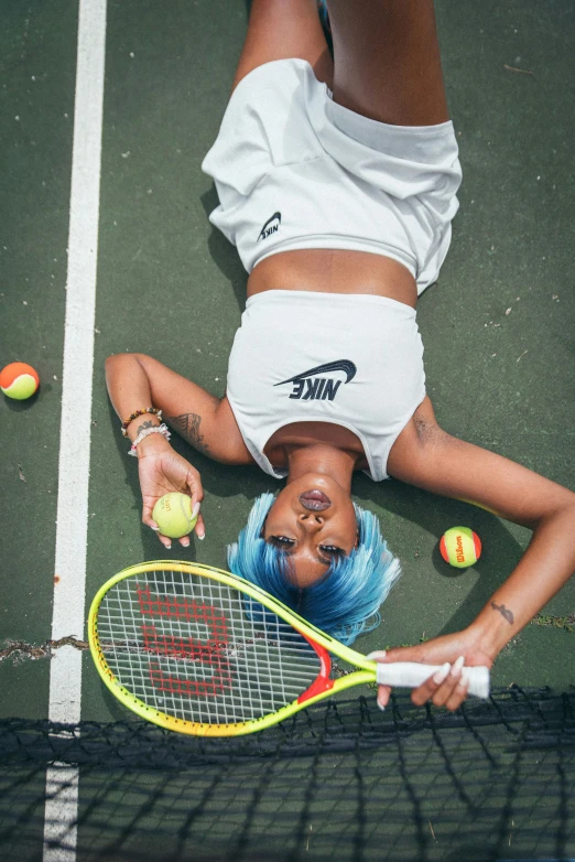 a woman with blue hair plays tennis