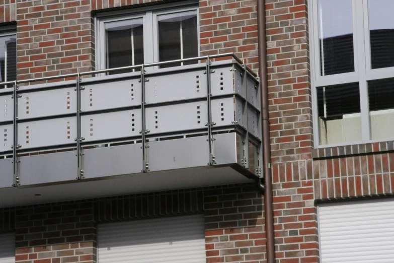 a metal balcony attached to a brick building