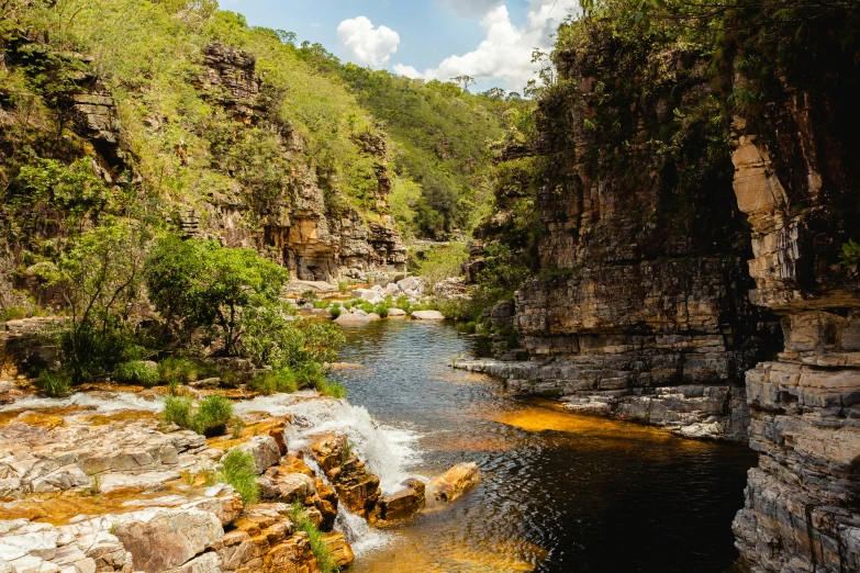 the small stream is in the middle of a mountain