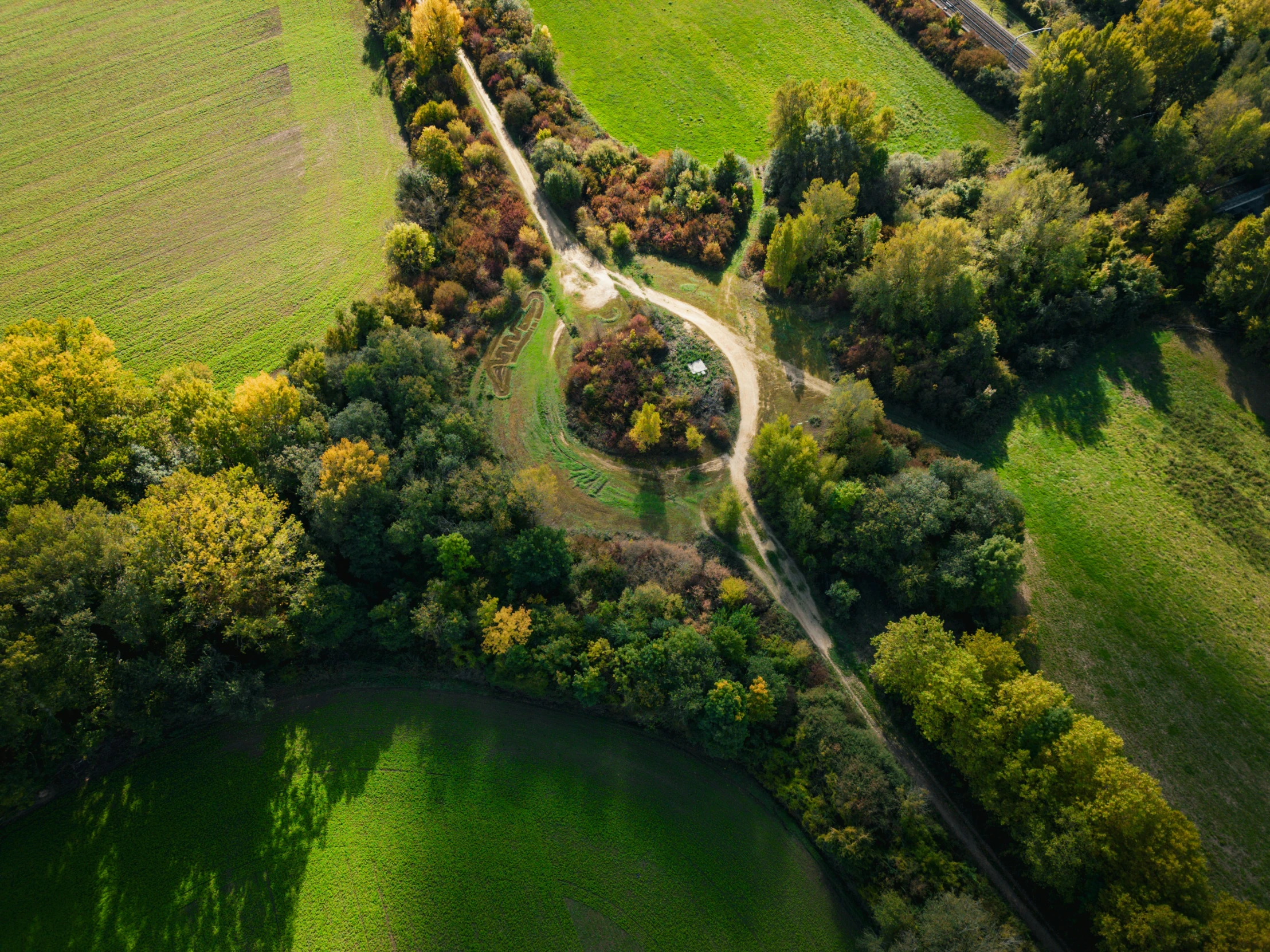 aerial view of two roads, fields and trees