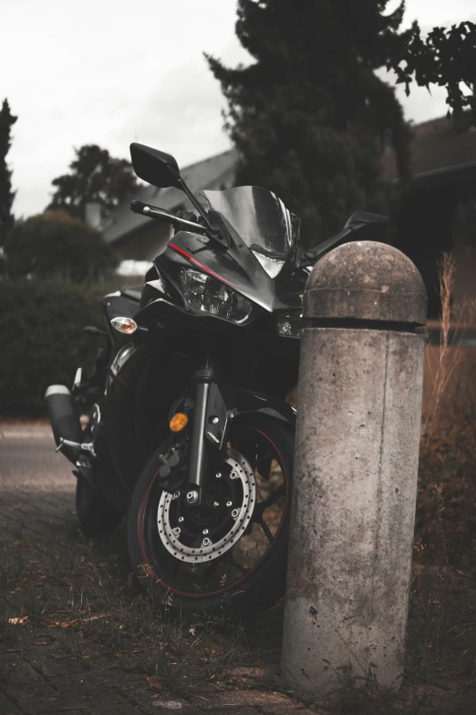 a motorcycle is shown parked near a cement post