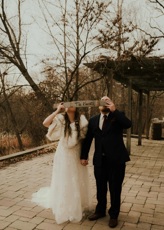 the bride and groom are looking up with their hands holding on to their nose