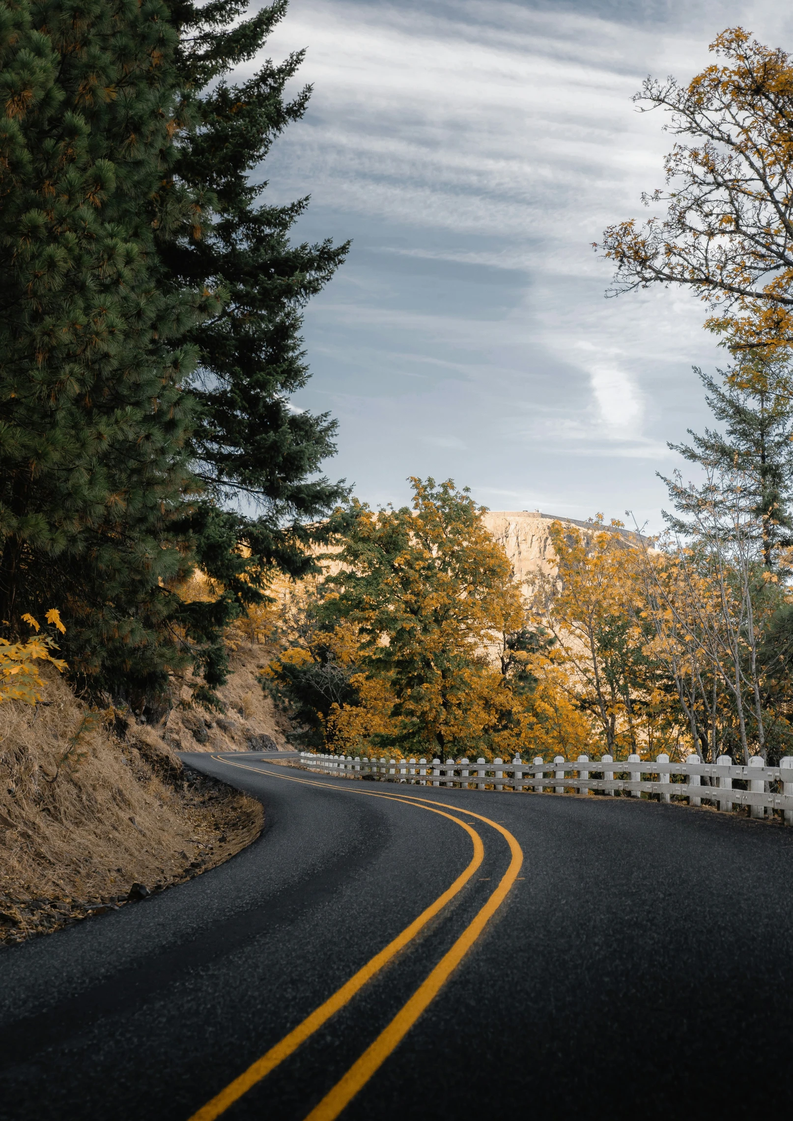 a lone car traveling down a rural highway