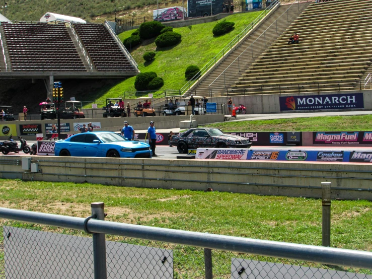 some cars driving by on the track at a racing track