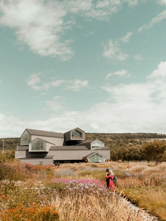 a person is standing in a field near a building