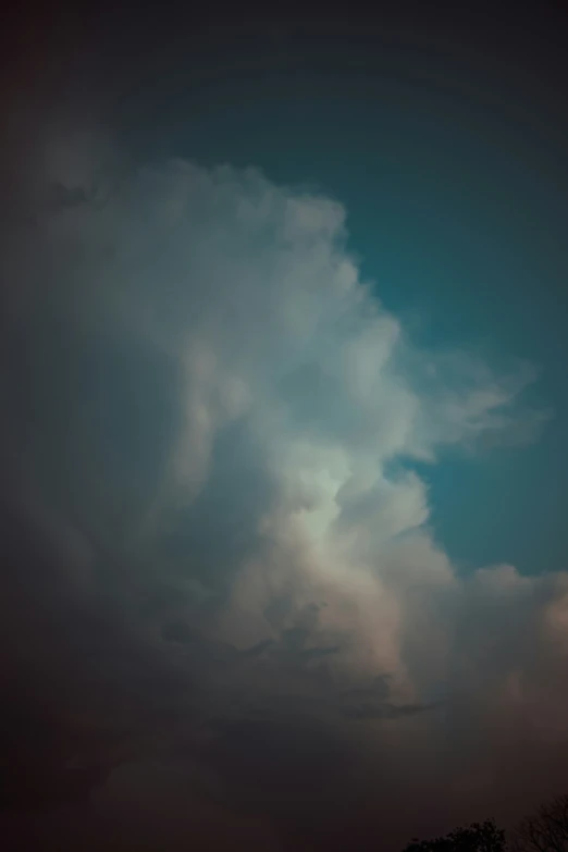 a dark, cloudy sky with an orange airplane in the foreground