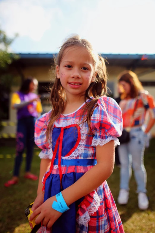 a little girl wearing a pink and blue dress