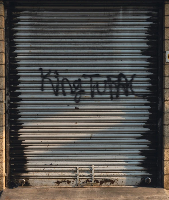 an open metal garage door with writing on the front