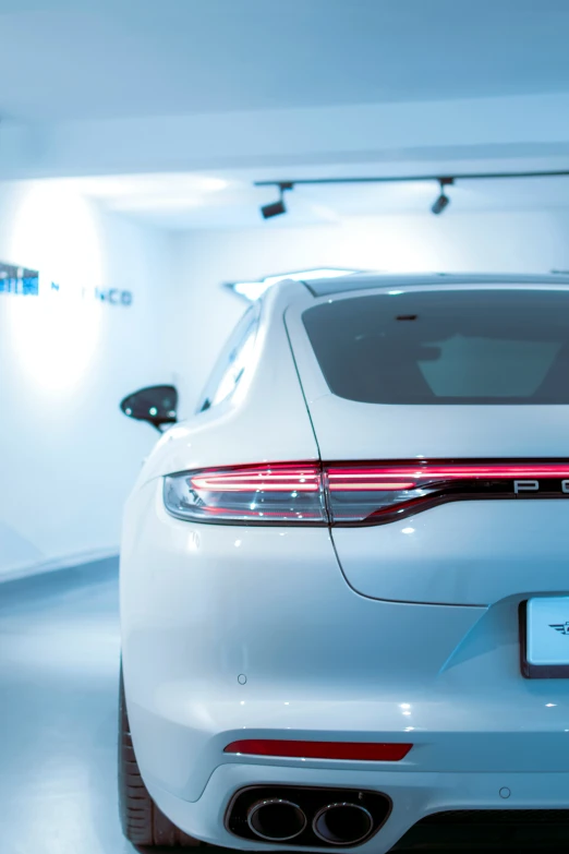 a white sports car parked inside of a showroom