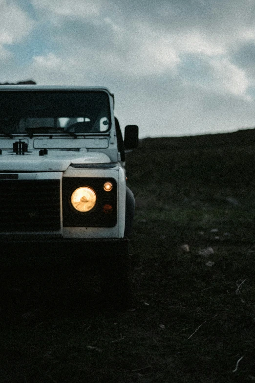 the front of a white truck is shown on a grassy hill