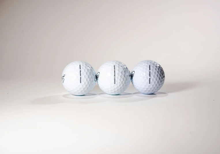 three different size golf balls sitting side by side