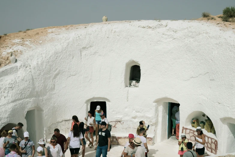 people walking in the street near a structure with a round structure