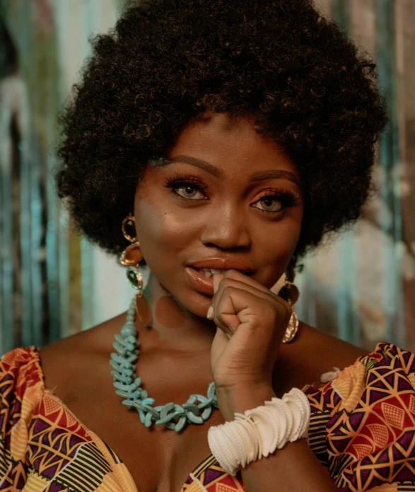 a black woman in colorful dress sitting down