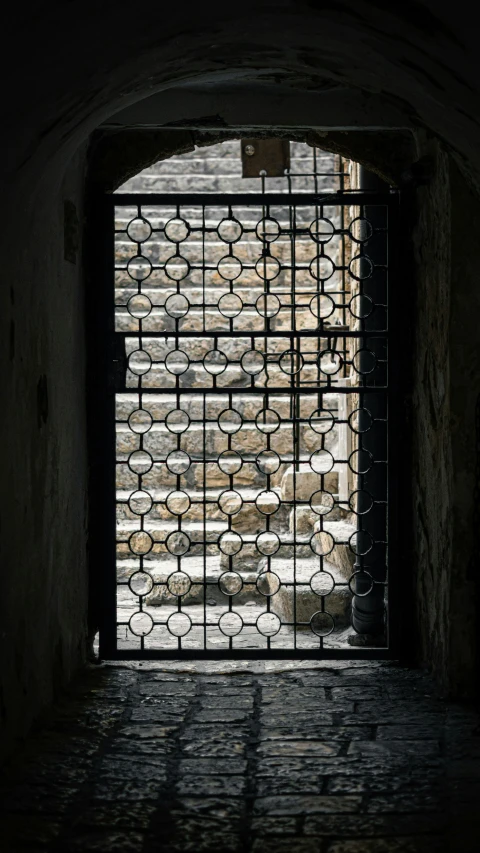 an iron gate with a brick wall behind it